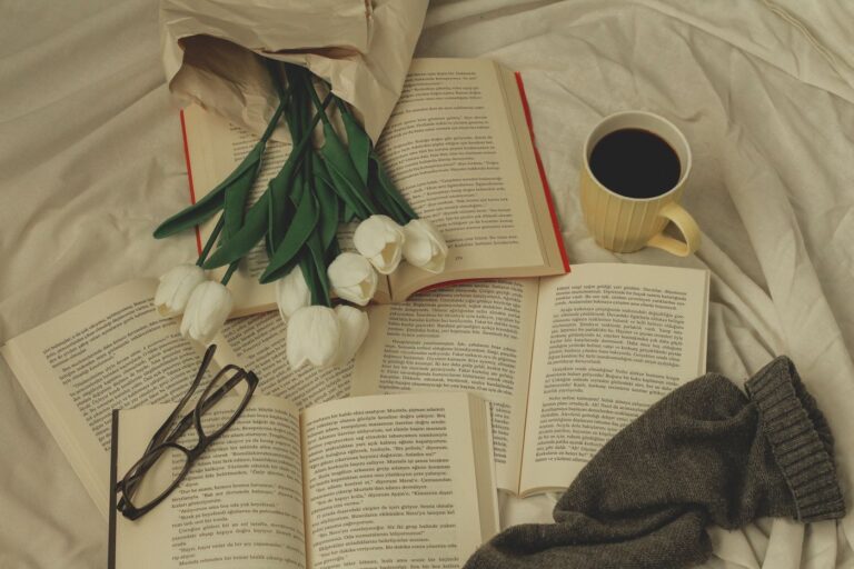 Cozy reading setup with books, flowers and a coffee mug