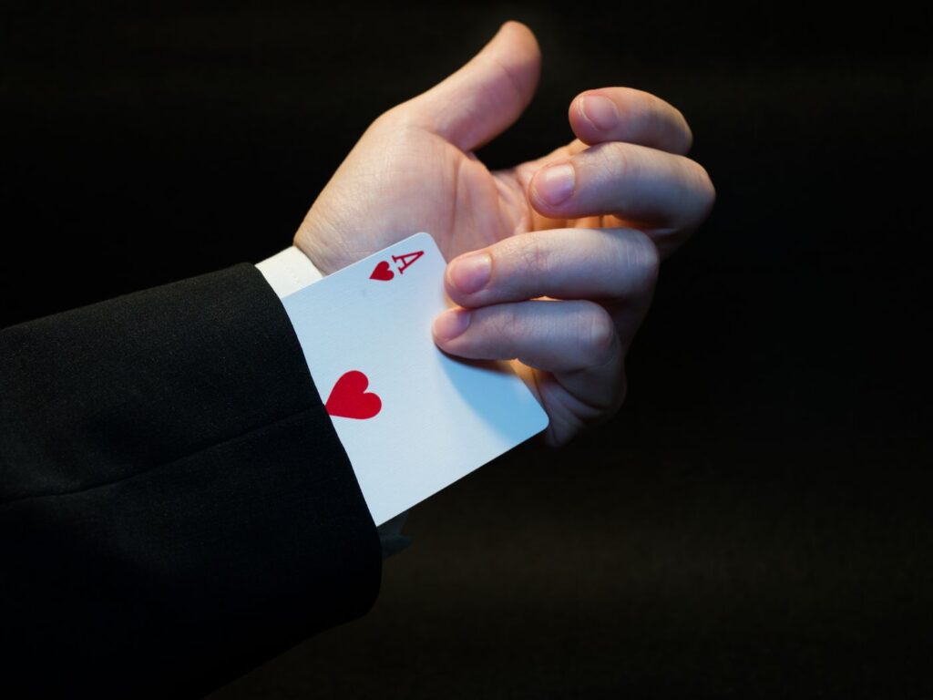 A magician revealing an ace of hearts card trick